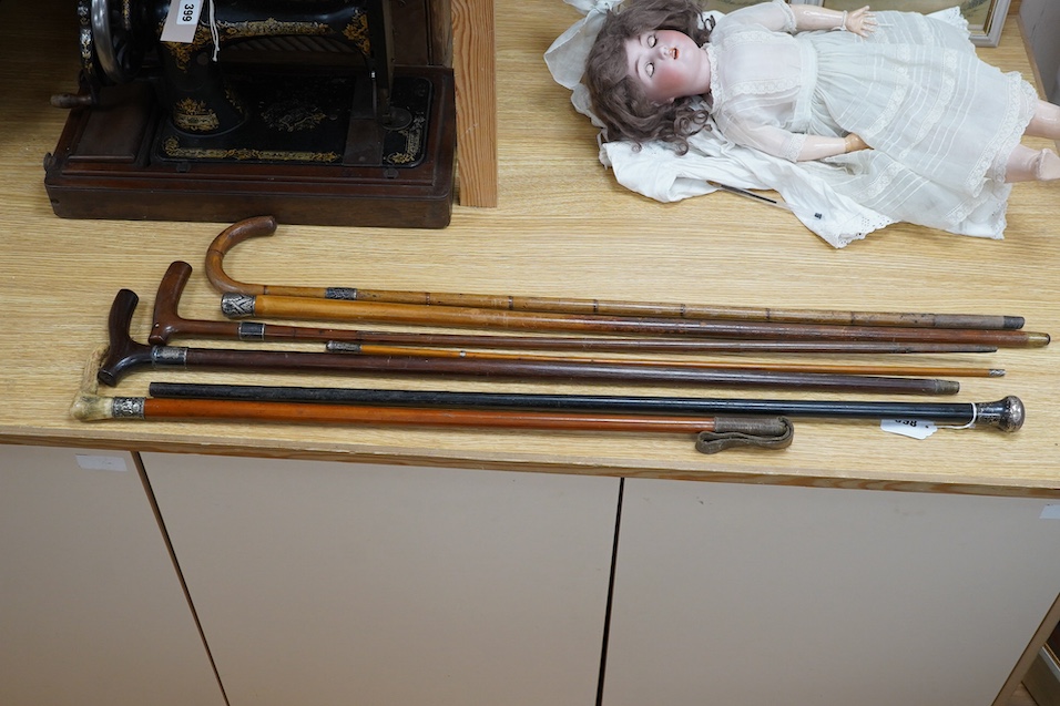 Four mixed silver mounted walking sticks, a riding crop and a baton, longest 88cm. (6). Condition - fair considering use and age